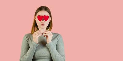 femme blonde avec des coeurs sur fond rose. portrait de studio de la saint-valentin.bannière de fond photo