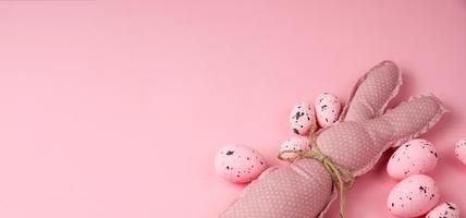 bannière de pâques rose monochrome avec lapins jouets et oeufs. place pour le texte photo