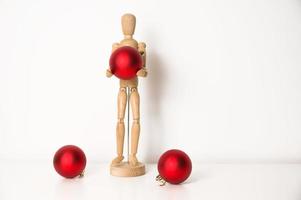 bannière festive avec place pour le texte. homme en bois tenant une grosse boule de noël rouge photo