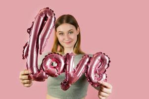 gros plan d'un ballon en forme d'amour dans les mains d'une belle femme. concept de la saint-valentin.romance photo