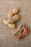 cacahuètes ouvertes fêlées avec coquille sur une toile de lin