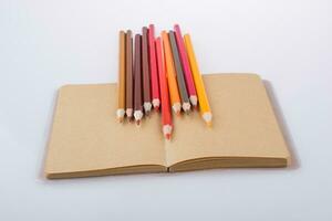 crayons de couleur posés sur un cahier photo