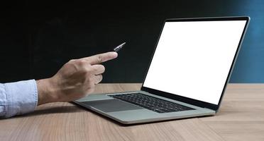 main d'homme d'affaires tenant un stylo pour afficher un ordinateur portable et une calculatrice sur la table photo