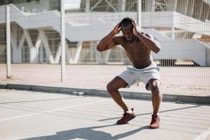 homme afro-américain fait des squats photo