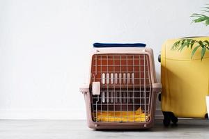 transporteur pour animaux de compagnie en plastique ou cage pour animaux de compagnie avec étui de voyage jaune sur le sol à la maison, coin pour animaux de compagnie transporteur pour animaux de compagnie en plastique ou cage pour animaux de compagnie avec étui de voyage jaune sur le sol à la maison, coin pour animaux de compagnie photo