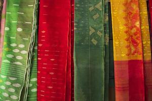 femmes bangladaises, s saree traditionnel jamdani coloré suspendu dans les salles d'exposition de détail. fond de texture saree jamdani coloré photo