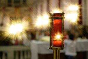 bougie votive allumée à l'intérieur d'une église représentant la lumière divine.lumière divine. photo