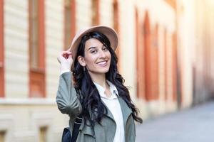portrait de mode de vie ensoleillé d'une jeune femme hipster élégante marchant dans la rue, portant une tenue à la mode, un chapeau, voyageant avec un sac à dos.