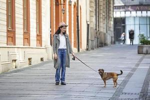 jeune femme séduisante promenant son chien dans la rue de la ville, concept de personnes lifestyle. beauté femme avec son chien jouant à l'extérieur photo