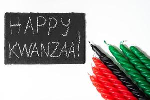 concept de kwanzaa heureux. vacances afro-américaines. lettrage de félicitations et sept bougies - rouge, noir et vert. symbole du patrimoine africain sur fond blanc. photo