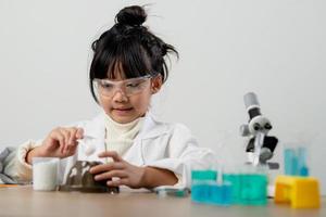 concept d'éducation, de science, de chimie et d'enfants - enfants ou étudiants avec expérience de fabrication de tubes à essai au laboratoire de l'école photo