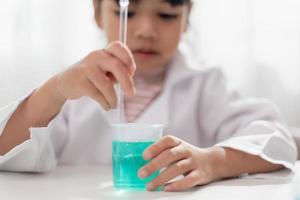 concept d'éducation, de science, de chimie et d'enfants - enfants ou étudiants avec expérience de fabrication de tubes à essai au laboratoire de l'école photo