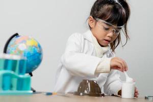 concept d'éducation, de science, de chimie et d'enfants - enfants ou étudiants avec expérience de fabrication de tubes à essai au laboratoire de l'école photo