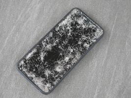 le smartphone a heurté le sol, il est tombé dans une fissure. photo