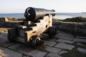 un canon avec un chariot en bois, sur le mur défensif dans les îles scilly photo