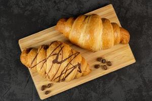 deux croissants frais sur fond sombre. vue de dessus photo