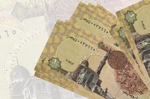Les billets de 1 livre égyptienne sont empilés sur fond de gros billets de banque semi-transparents. présentation abstraite de la monnaie nationale photo