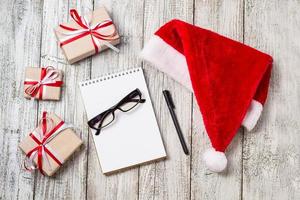 articles de noël et d'affaires avec espace de copie santa cap notepad stylo lunettes et coffrets cadeaux décorés photo