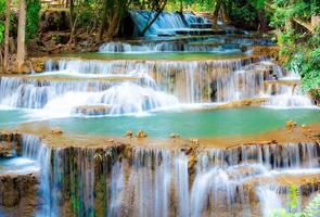 incroyable cascade colorée dans la forêt du parc national au printemps, belle forêt profonde en thaïlande, longue exposition technique, pendant les vacances et les moments de détente. photo