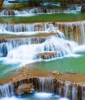 incroyable cascade colorée dans la forêt du parc national au printemps, belle forêt profonde en thaïlande, longue exposition technique, pendant les vacances et les moments de détente. photo