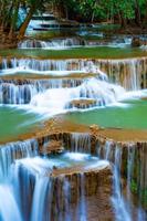 incroyable cascade colorée dans la forêt du parc national au printemps, belle forêt profonde en thaïlande, longue exposition technique, pendant les vacances et les moments de détente. photo