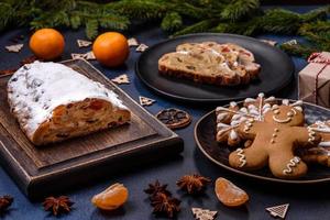 délicieuse tarte festive du nouvel an avec des fruits confits, du massepain et des noix sur un fond de béton foncé