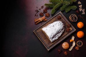 tarte de noël volée avec du massepain, des baies et des noix sur un fond de béton foncé photo