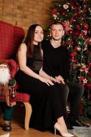 joyeux noël et joyeuses fêtes passion couple amoureux s'amuser, étreindre s'embrasser près de l'arbre de noël. famille heureuse aimante avec des cadeaux à l'intérieur de la chambre décorée photo