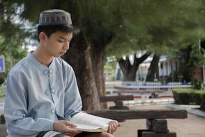 portrait jeune garçon islamique ou musulman d'asie du sud-est en chemise blanche et chapeau, isolé sur blanc, mise au point douce et sélective. photo