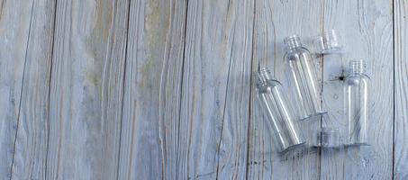 tube en plastique transparent sur un fond en bois bleu. bouteille vide en plastique pour détergent détergent. bannière photo