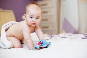 bébé mignon regardant la caméra sous une serviette blanche. portrait d'un enfant mignon photo