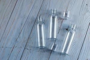 tube en plastique transparent sur un fond en bois bleu. bouteille vide en plastique pour détergent détergent.