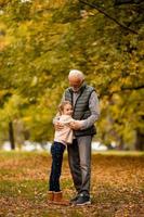 grand-père passe du temps avec sa petite-fille dans le parc le jour de l'automne photo