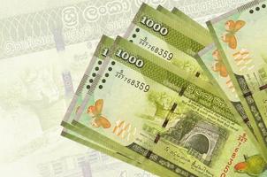 1000 billets de roupies sri lankaises sont empilés sur fond de gros billets semi-transparents. présentation abstraite de la monnaie nationale photo