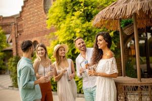 groupe de jeunes applaudissant et s'amusant à l'extérieur avec des boissons photo