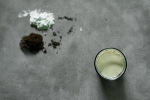 boisson au lait de café avec des ingrédients crus sur fond de béton photo