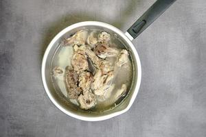 soupe de bouillon de poulet dans une casserole sur un fond de béton photo