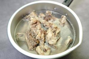 soupe de bouillon de poulet dans une casserole sur un fond de béton photo