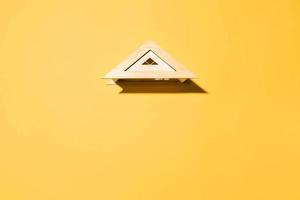 toit en bois jouet sur fond jaune vue de dessus, espace de copie. concept de logement, assurance, espace publicitaire photo