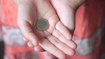 l'enfant tient une pièce de 1 euro dans ses mains. photo