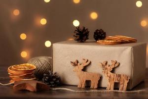 cadeau de papier de Noël fait à la main. coffret cadeau d'artisanat de noël avec des jouets en bois de noël. emballage de préparation du réveillon de noël. boîte cadeau d'emballage. décor de style éco rustique naturel photo