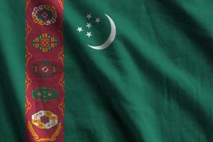 drapeau du turkménistan avec de grands plis agitant de près sous la lumière du studio à l'intérieur. les symboles et couleurs officiels de la bannière photo