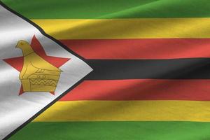 drapeau du zimbabwe avec de grands plis agitant de près sous la lumière du studio à l'intérieur. les symboles et couleurs officiels de la bannière photo