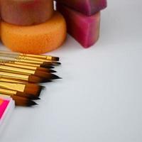 cosmétiques de couleur, pinceaux et éponges pour la peinture faciale sur fond blanc photo