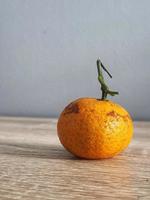 c'est une photo d'une petite orange sur une table en bois.