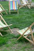 chaises longues sur une pelouse. transats de jardin sur l'herbe verte photo