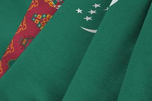 drapeau du turkménistan avec de grands plis agitant de près sous la lumière du studio à l'intérieur. les symboles et couleurs officiels de la bannière photo
