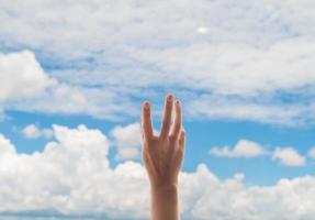 mains en prière sur fond de ciel bleu, jeune homme a prié, religion et spiritualité avec foi photo