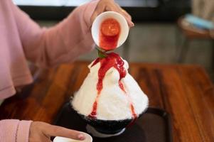 dessert coréen à la glace pilée avec garnitures sucrées, bingsu aux fraises sur table en bois photo