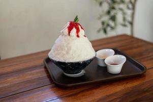 dessert coréen à la glace pilée avec garnitures sucrées, bingsu aux fraises sur table en bois photo